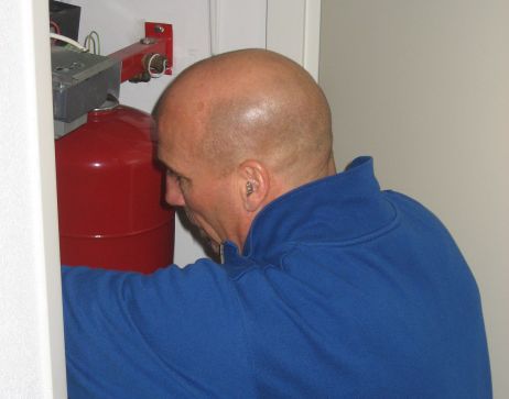 Monteur Ruud Kerskes in 2015 bezig met onderhoud aan een verwarmingsketel.